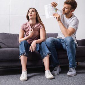 couple faning themselves on the couch because their ac is broken