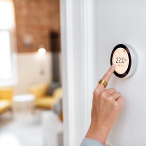 woman adjusting thermostat