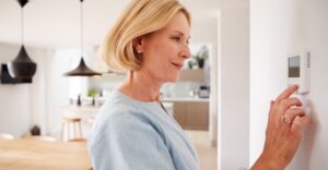 a woman looking at a thermostat